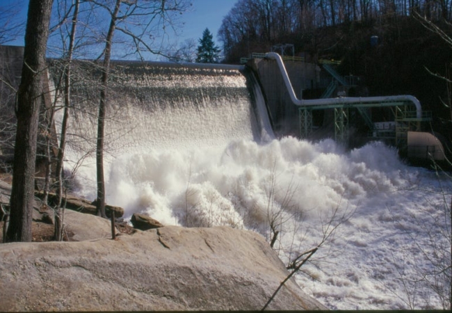 Water rushing over the Gorge Dam and crashing in the river below.