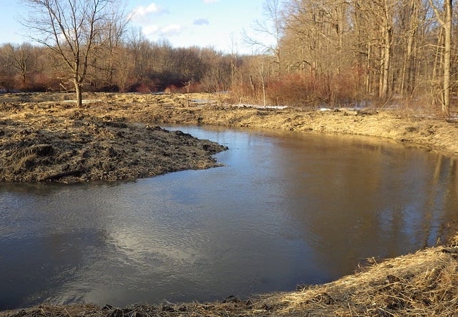 The Cuyahoga River bends through recently plowed and seeded land.