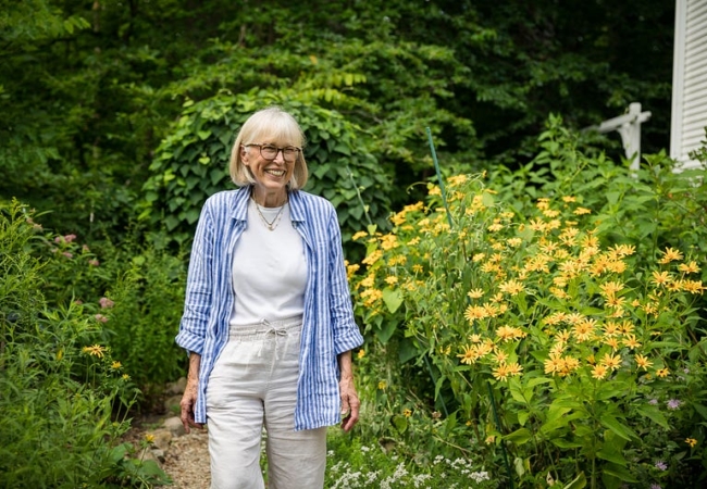 Marcia Carsten smiles as she walks through her garden full of tall native plants.