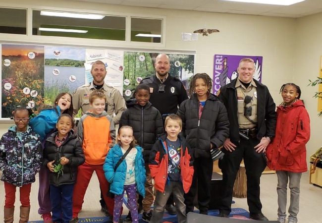 A group photo of three Summit Metro Parks rangers with a group of kids.