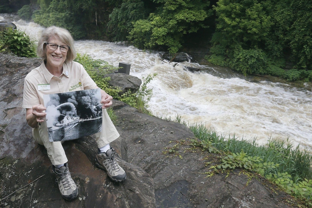 Elaine compares the dramatic impact that conservation efforts have had on the Cuyahoga River as she poses by a freed section of rapids in June 2019. Photo by Phil Masturzo / Akron Beacon Journal