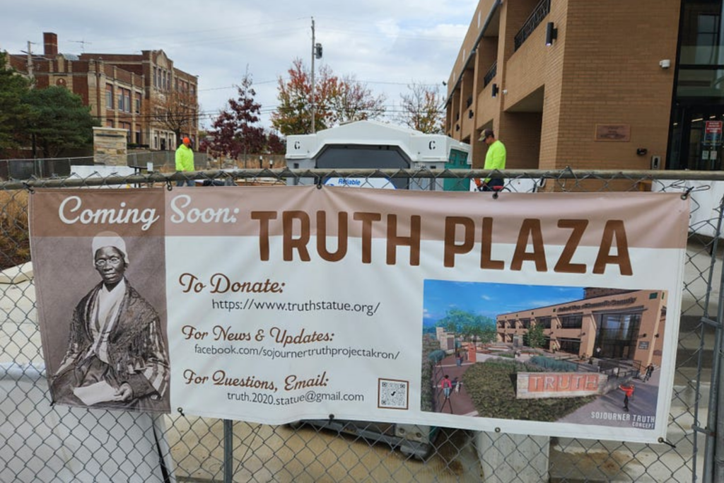 banner on construction site showing rendering of Truth Plaza