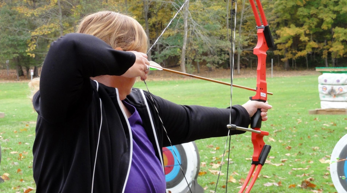 Woman shooting an arrow at an archery range