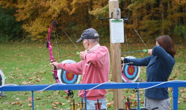 Two people shooting bows and arrows