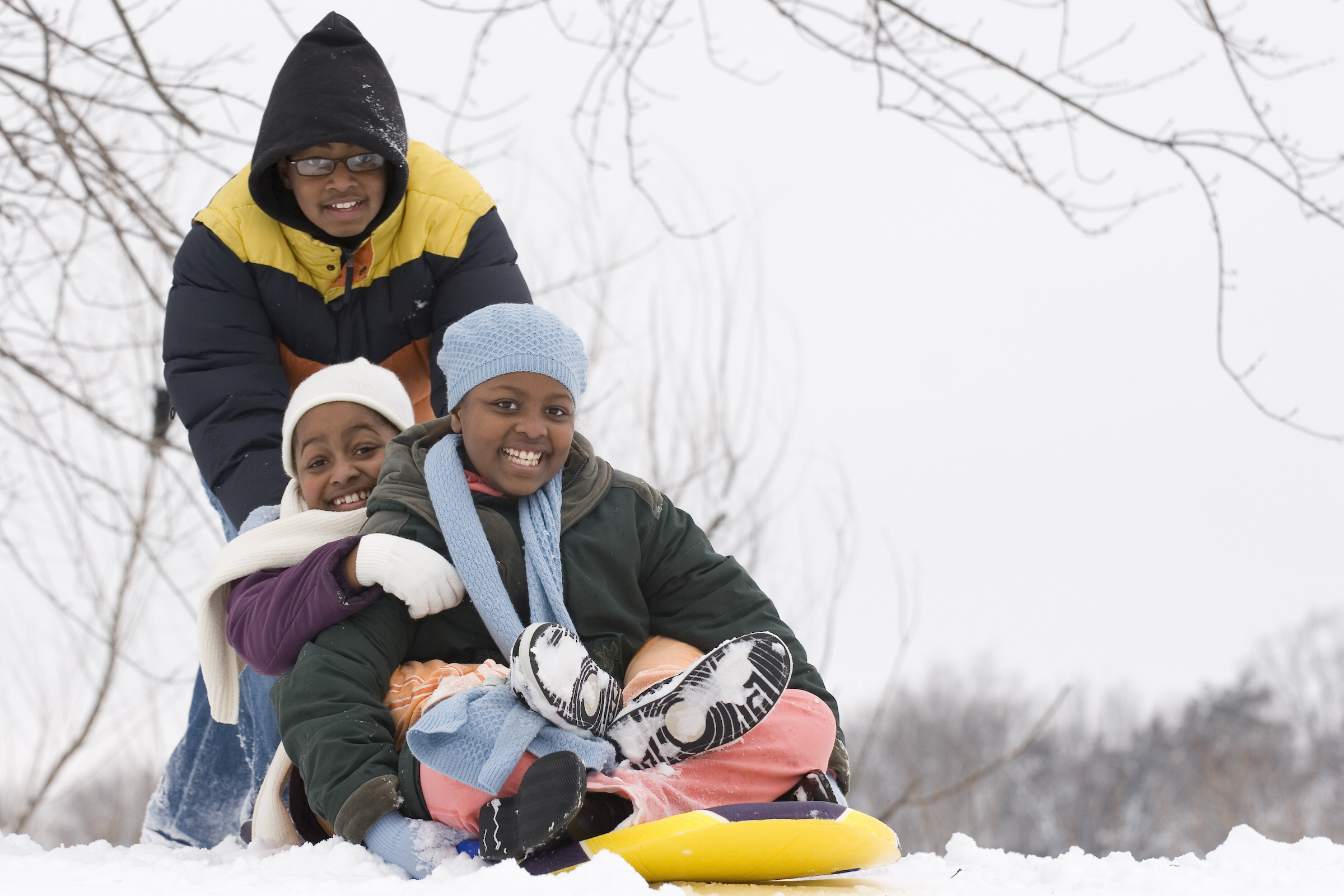 Children preparing to slide down a hill on a sled